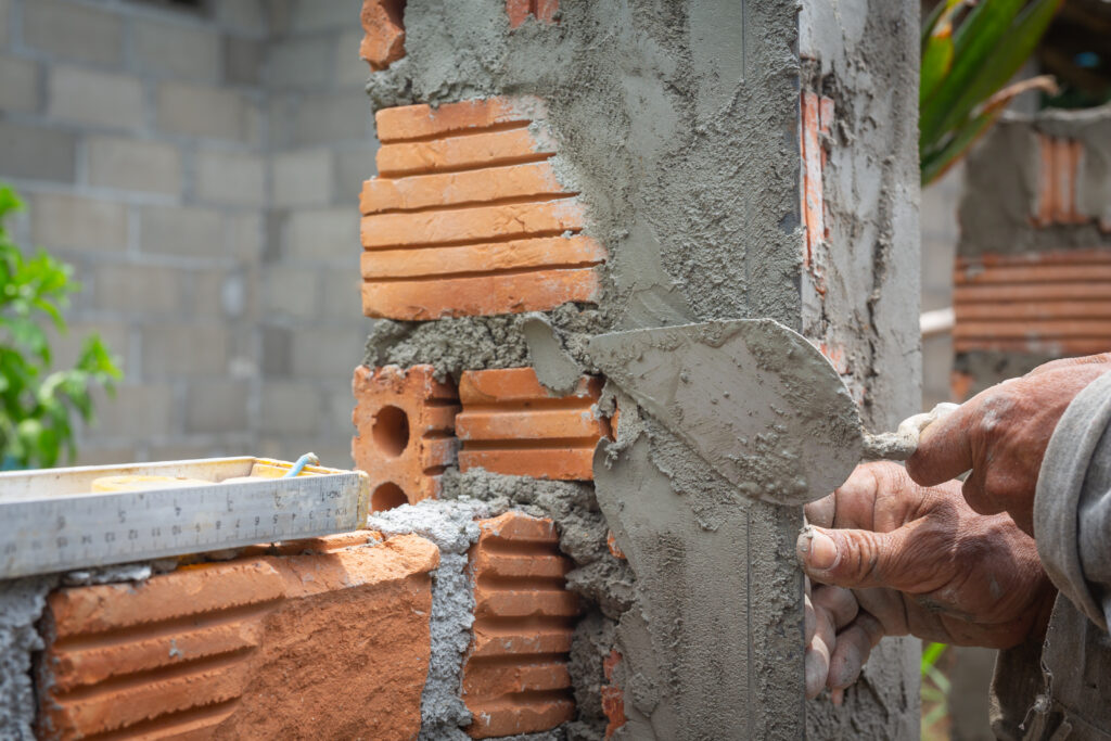 Construction worker building a durable brick wall for a home renovation.